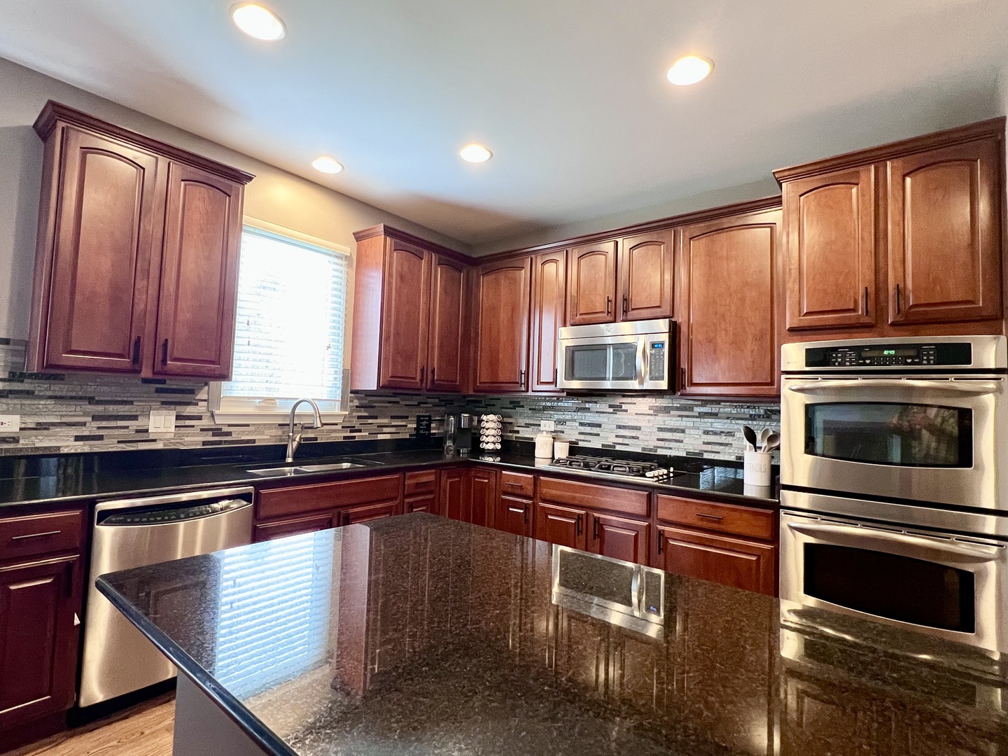 407 Post Oak Circle West Chicago, IL 60185 - Photo 2 of 23 a kitchen with stainless steel appliances granite countertop wooden cabinets a stove top oven a sink and dishwasher