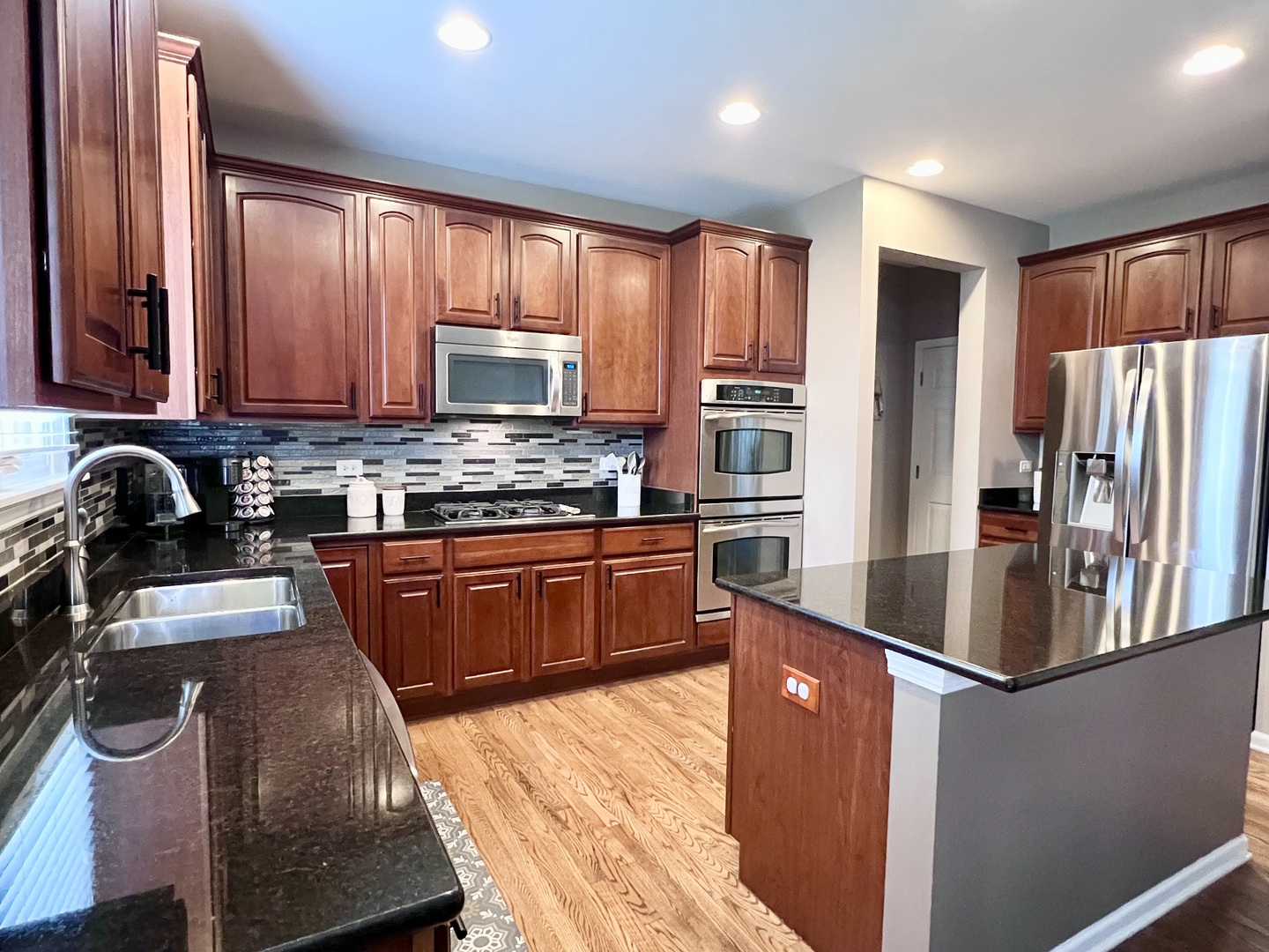 407 Post Oak Circle West Chicago, IL 60185 - Photo 3 of 23 a kitchen with stainless steel appliances granite countertop a refrigerator a stove top oven a sink and dishwasher