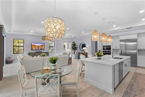 a view of a dining room with furniture a chandelier and wooden floor