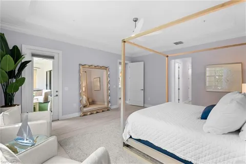a spacious bedroom with a bed a couch and a potted plant