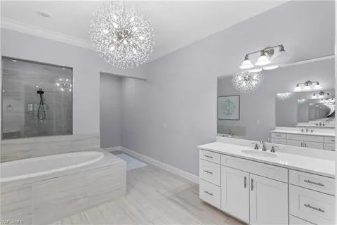 a bathroom with a bathtub a double vanity sink and a mirror