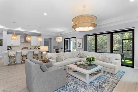 a living room with furniture potted plant and a large window