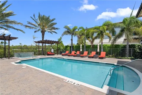 a view of a chairs and table in patio with a swimming pool