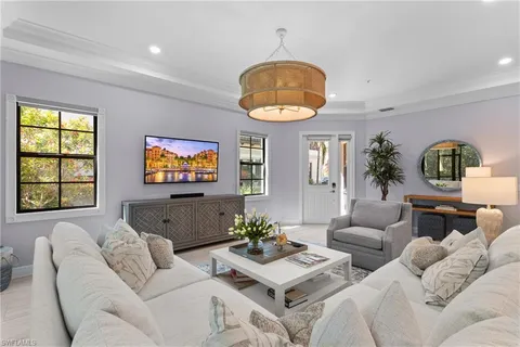 a living room with furniture a chandelier and a window