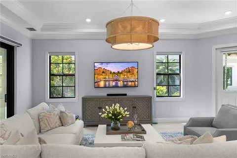 a living room with furniture chandelier and window