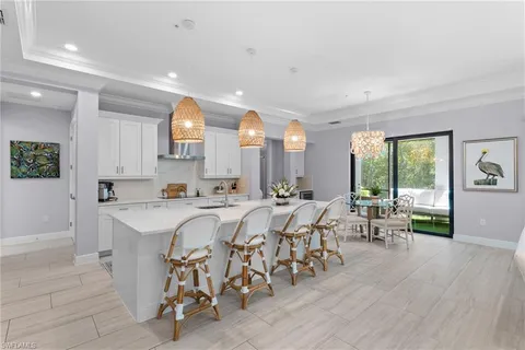 a large white kitchen with lots of counter space a sink and appliances