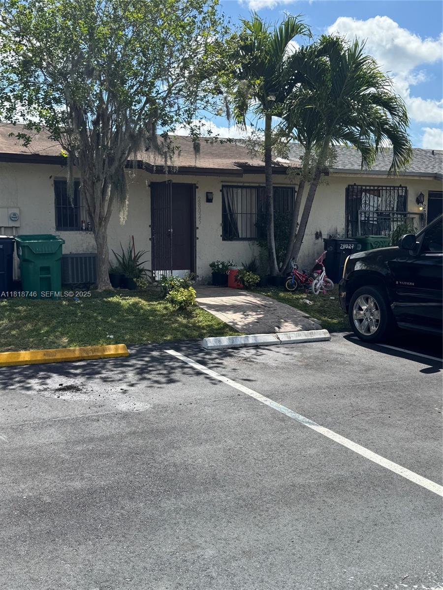 28152 Southwest 142nd Court Homestead, FL 33033 - Photo 7 of 12 a view of a house with a patio and a yard