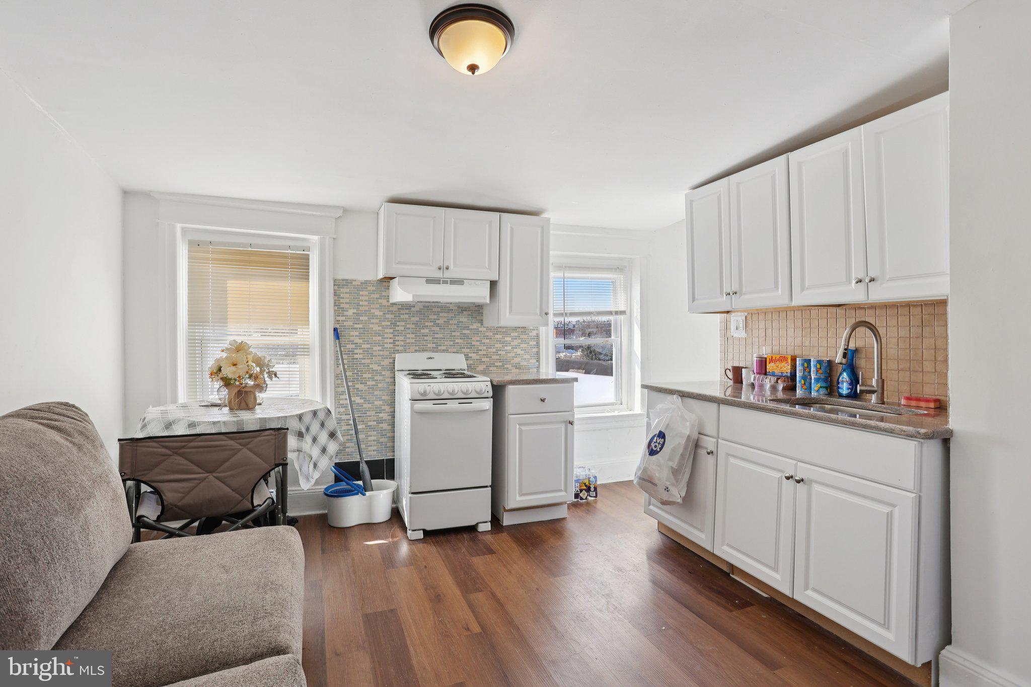 1540 Adams Avenue Philadelphia, PA 19124 - Photo 26 of 43 a kitchen with a refrigerator a stove top oven a sink dishwasher and white cabinets with wooden floor
