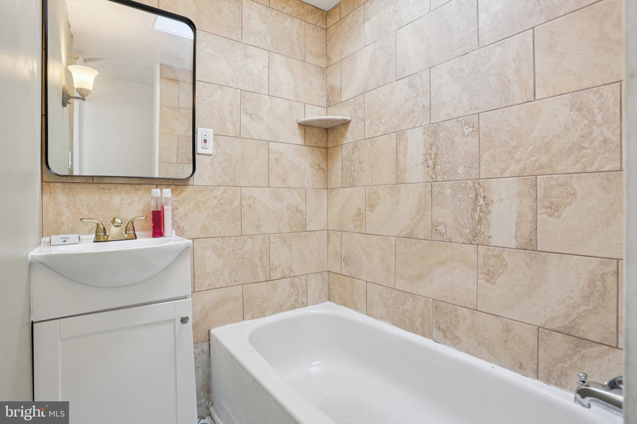 1540 Adams Avenue Philadelphia, PA 19124 - Photo 29 of 43 a bathroom with a bathtub sink vanity and mirror