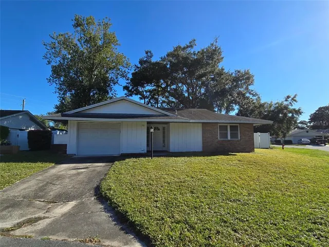 a front view of a house with yard and trees