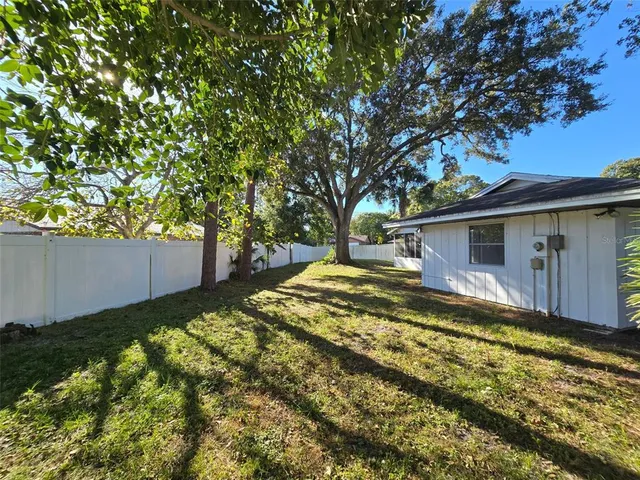 a view of a house with backyard and sitting area