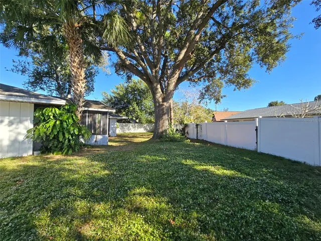 a view of a big house with a big yard and large tree