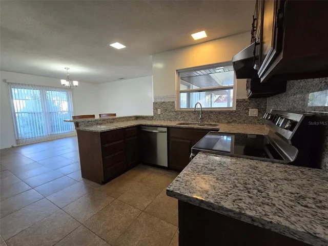 a kitchen with kitchen island granite countertop a sink counter and cabinets