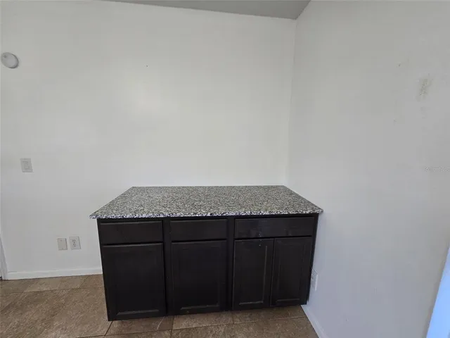 a bathroom with a granite countertop toilet sink and mirror