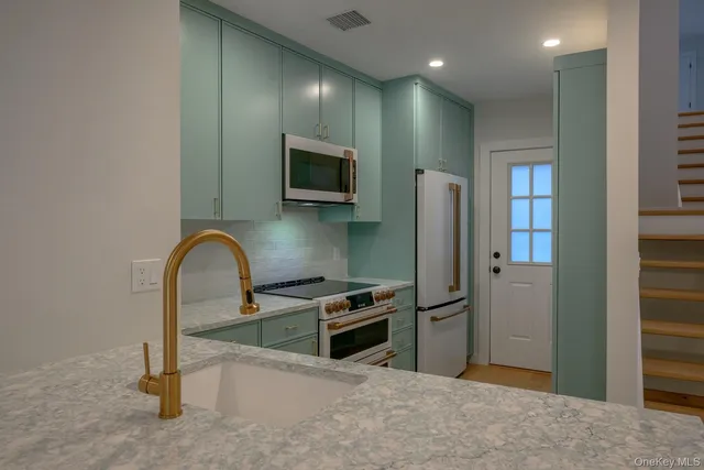 a kitchen with stainless steel appliances a refrigerator and a stove top oven