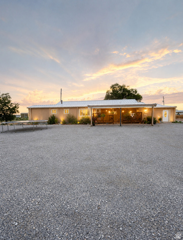 615 North 250 W Road Hinckley, UT 84635 - Photo 1 of 16 Stucco exterior with a covered porch, string lighting, recessed lighting, and a metal roof