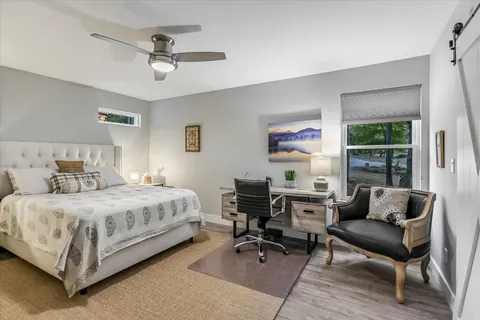 a bedroom with a bed and a large window with the outer view