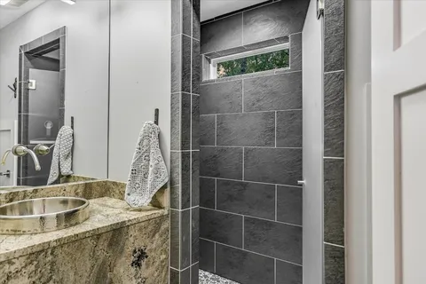 a bathroom with a granite countertop sink vanity and mirror