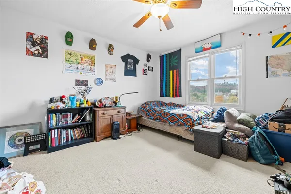 a bedroom with furniture a rug toys and a window