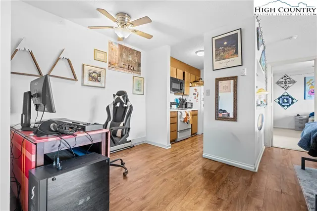 a view of a workspace with furniture and wooden floor