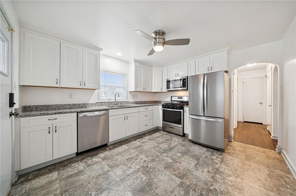 253 Stewart Street Elizabeth, PA 15037 - Photo 8 of 23 a kitchen with stainless steel appliances granite countertop a refrigerator sink and white cabinets