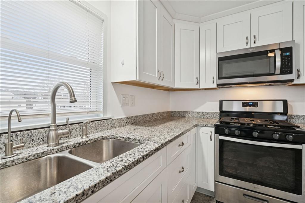253 Stewart Street Elizabeth, PA 15037 - Photo 9 of 23 a kitchen with stainless steel appliances granite countertop white cabinets a stove a sink and dishwasher