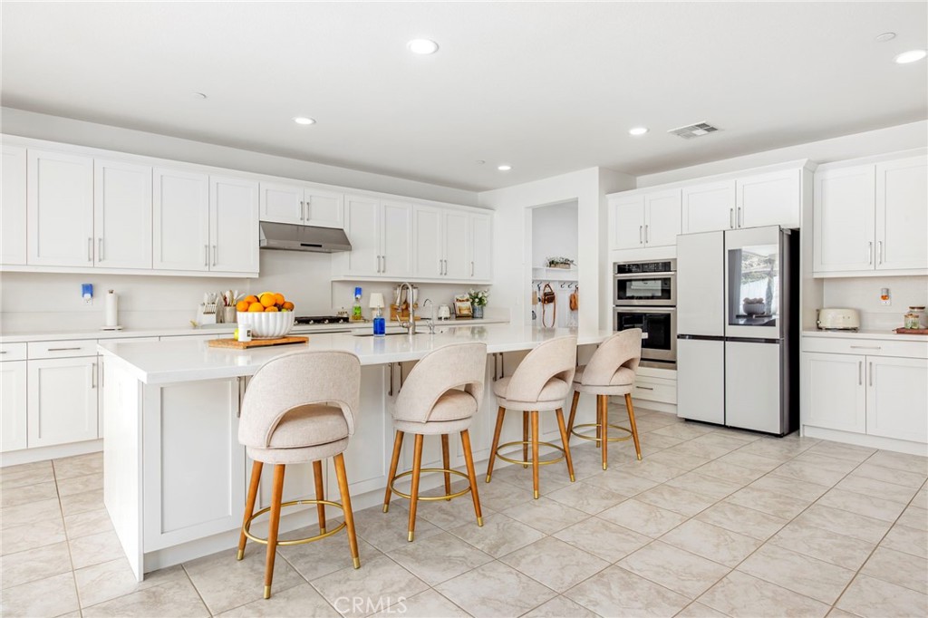 32797 Hayden Road Menifee, CA 92584 - Photo 15 of 51 a kitchen with stainless steel appliances kitchen island granite countertop a refrigerator and white cabinets