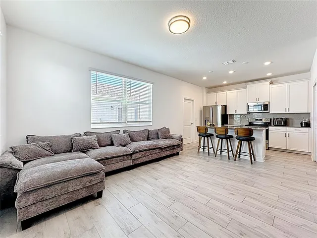 a living room with furniture and kitchen view