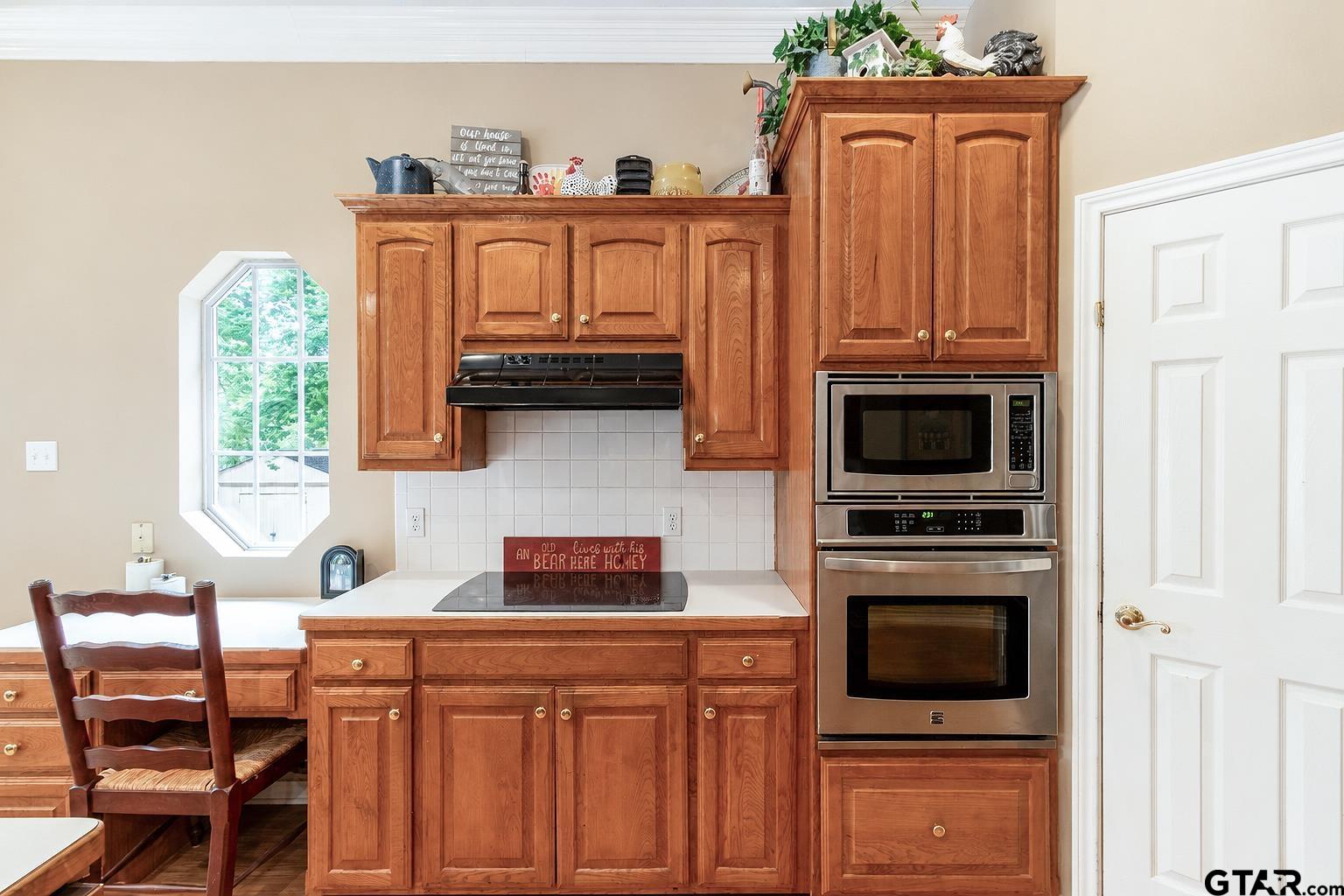 1388 Santa Fe Trail Tyler, TX 75703 - Photo 27 of 46 a kitchen with stainless steel appliances granite countertop a stove a microwave and wooden cabinets