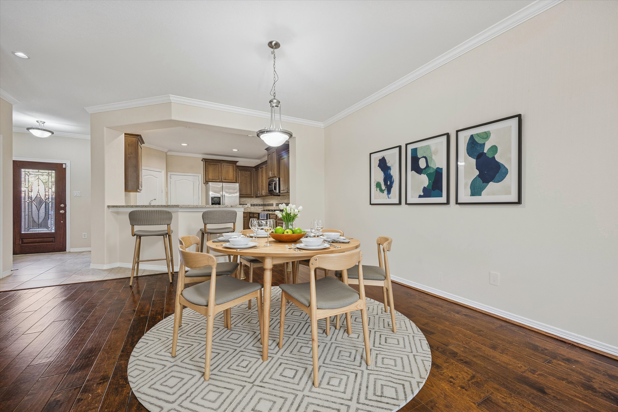 1113 Peden Street, Unit B Houston, TX 77006 - Photo 6 of 19 a dining room with wooden floor a chandelier a wooden table and chairs