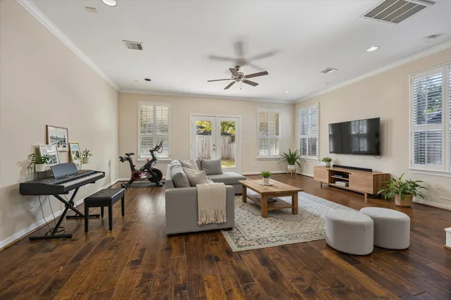 a living room with furniture flat screen tv and wooden floor