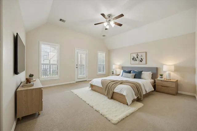a spacious bedroom with a bed and a chandelier