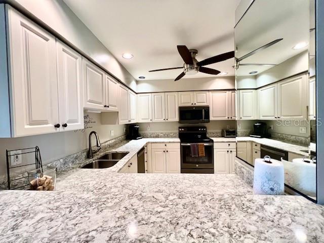 2060 Matecumbe Key Road, Unit 2102 Punta Gorda, FL 33955 - Photo 13 of 51 a kitchen with granite countertop a refrigerator sink and wooden cabinets