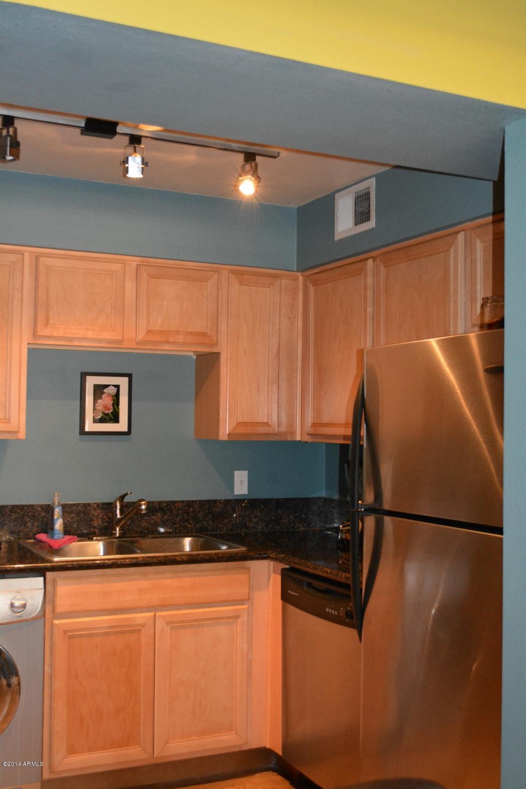 5401 East Thomas Road, Unit 1032 Phoenix, AZ 85018 - Photo 11 of 34 a kitchen with stainless steel appliances granite countertop a refrigerator and a sink
