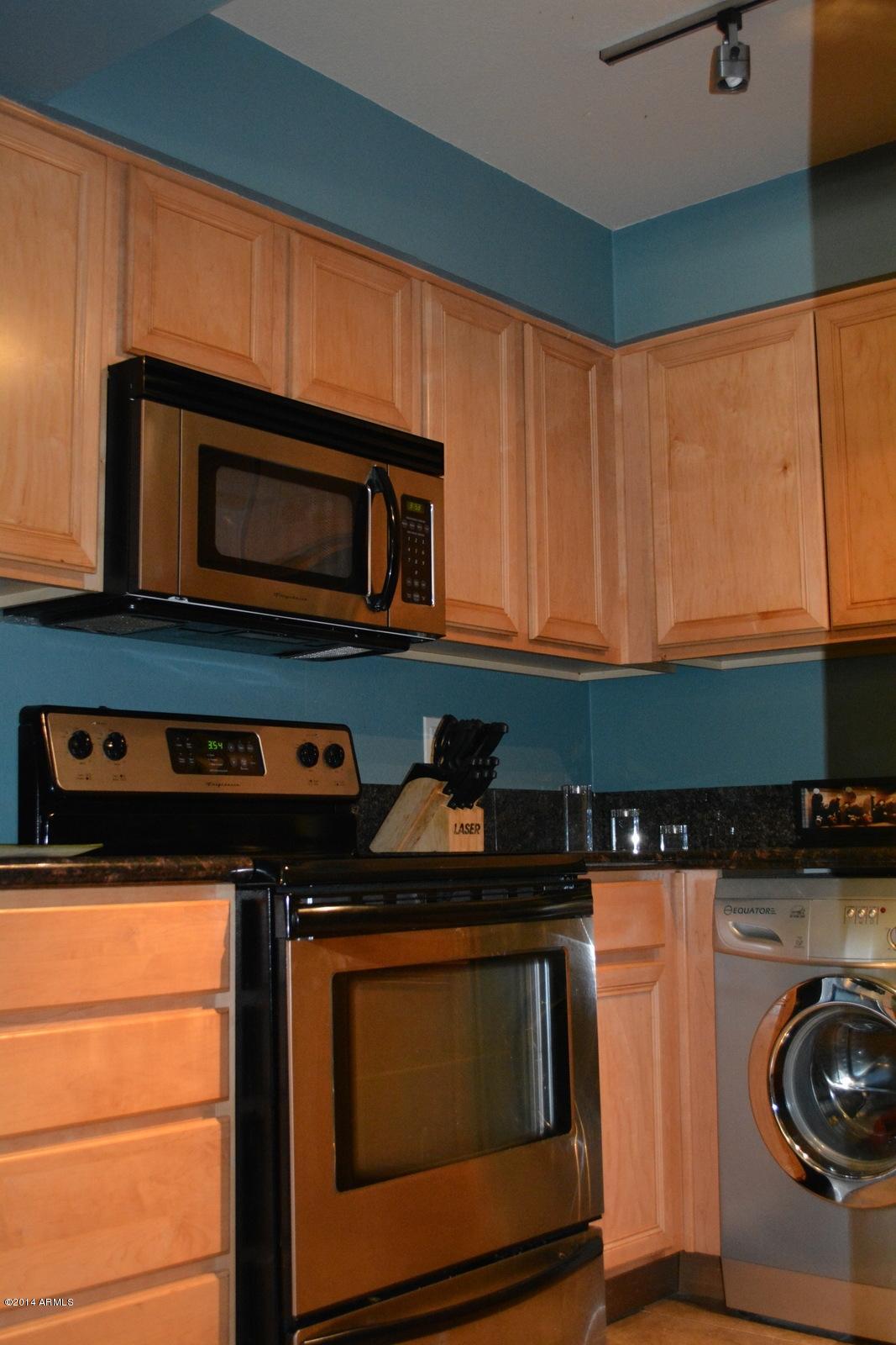 5401 East Thomas Road, Unit 1032 Phoenix, AZ 85018 - Photo 17 of 34 a kitchen with granite countertop a stove top oven microwave and cabinets
