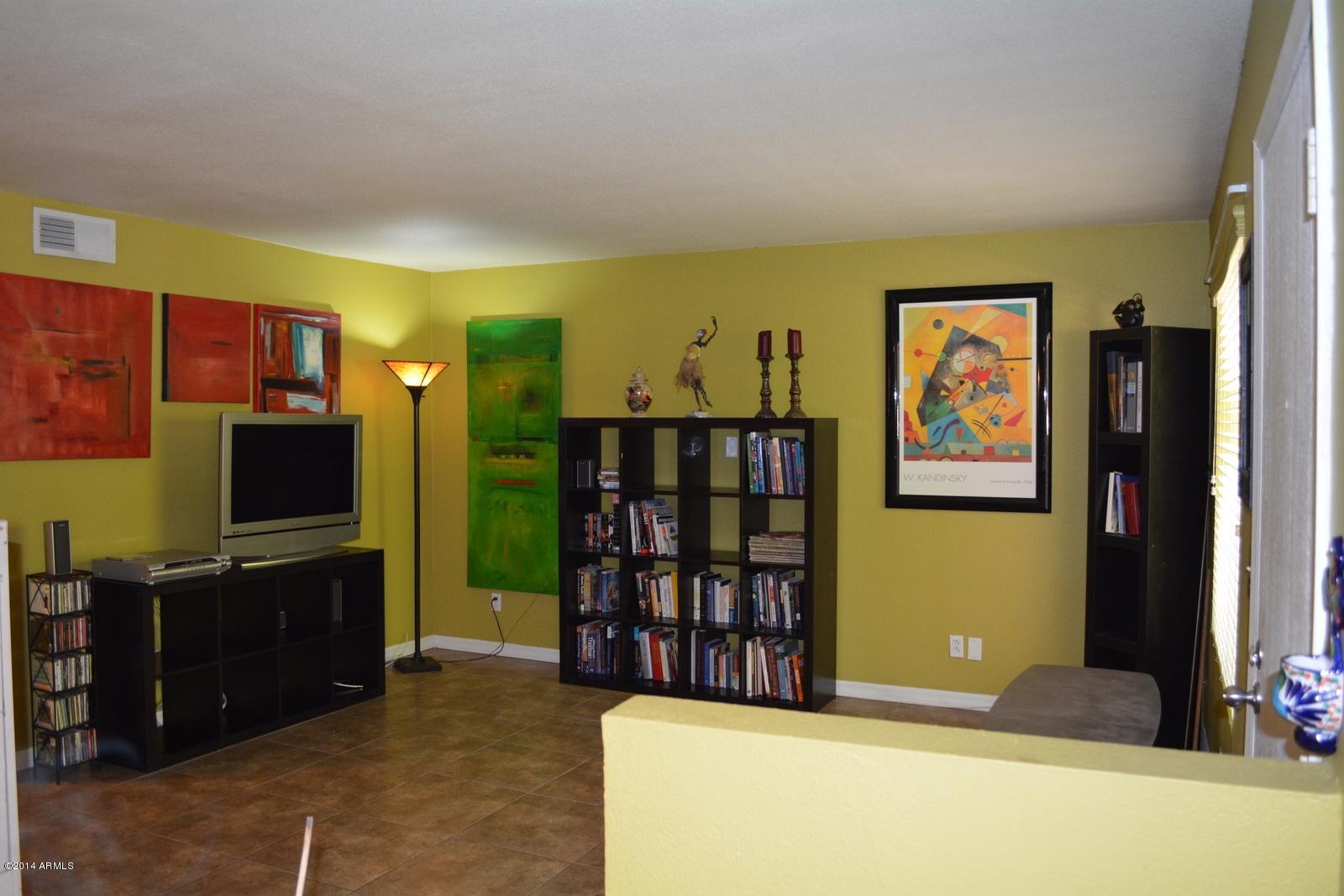 5401 East Thomas Road, Unit 1032 Phoenix, AZ 85018 - Photo 2 of 34 a living room with flat screen tv and bookshelf