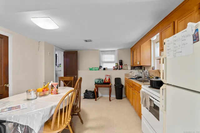 a kitchen with a table chairs a sink dishwasher window and cabinets
