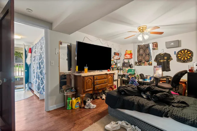 a living room with furniture and a dining table with kitchen appliances