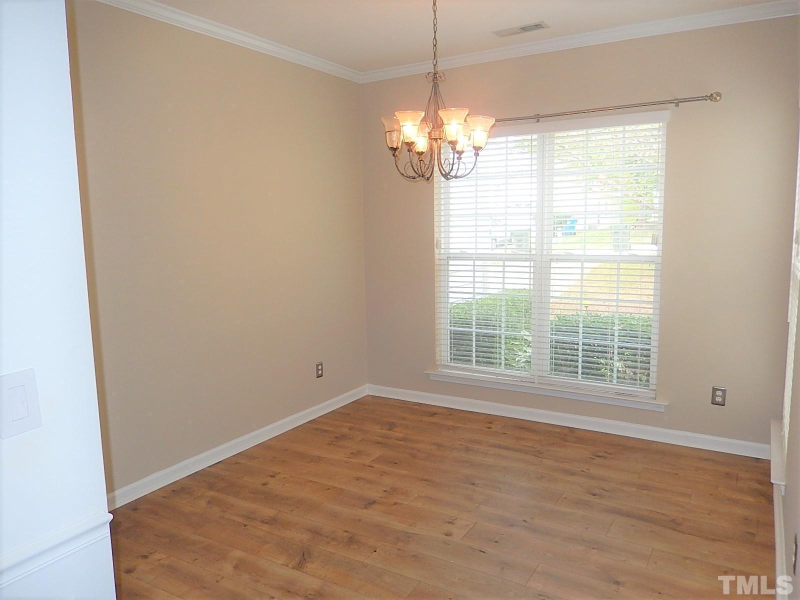 4717 Delta Ridge Court Raleigh, NC 27612 - Photo 2 of 30 a view of an empty room with wooden floor and a window
