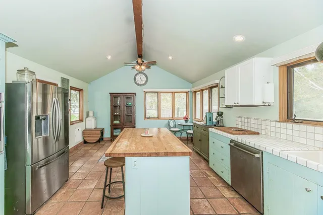 a kitchen with a sink a counter top space stainless steel appliances and cabinets