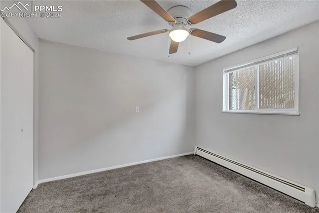 an empty room with a window and a fan