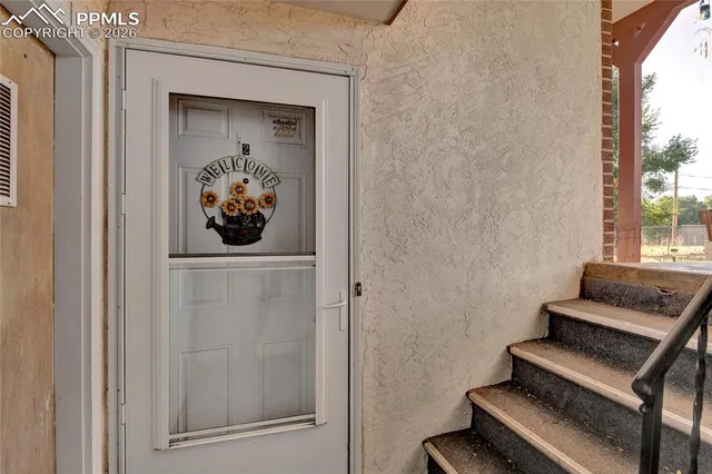 a view of a hallway with wooden floor and a window