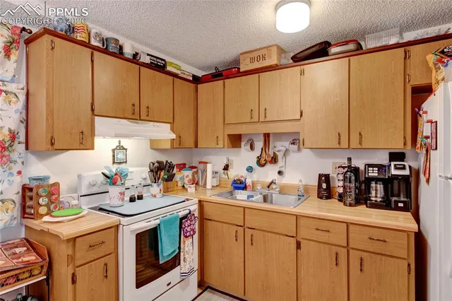 a kitchen with stainless steel appliances cabinets a sink and a refrigerator