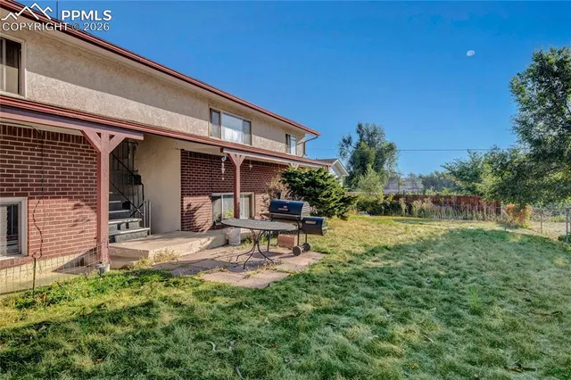 a backyard of a house with table and chairs