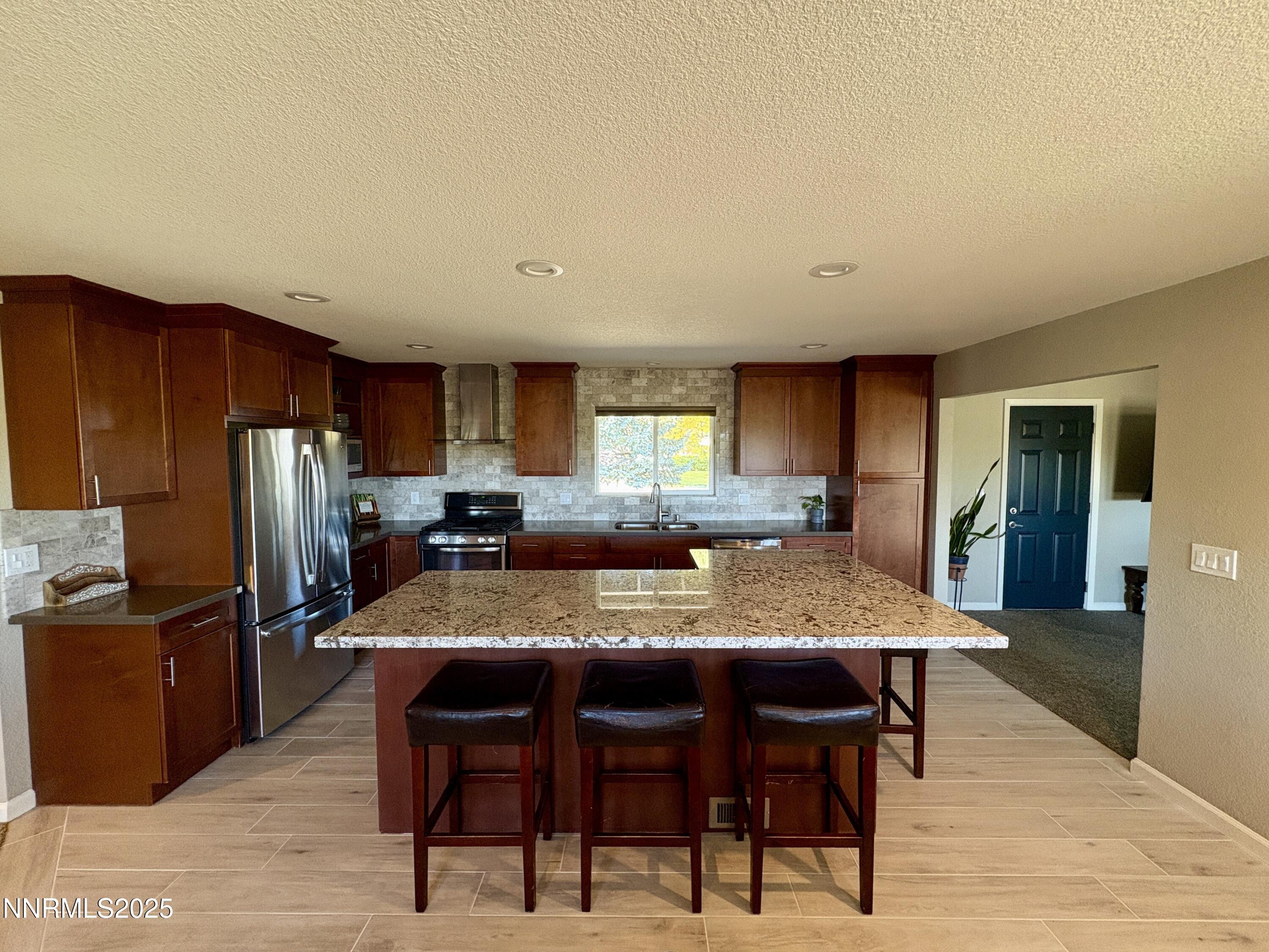 2000 Royal Drive Reno, NV 89503 - Photo 7 of 33 a kitchen with stainless steel appliances granite countertop a table chairs refrigerator and sink