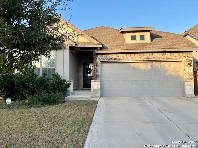a front view of a house with yard and garage
