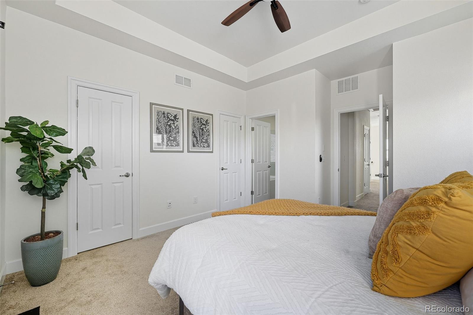 5207 Clinton Street Denver, CO 80238 - Photo 18 of 43 a bedroom with a bed and a potted plant