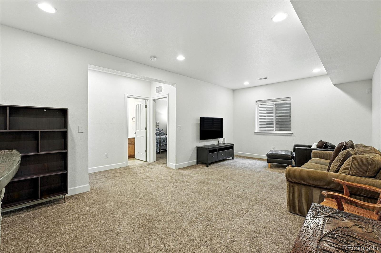5207 Clinton Street Denver, CO 80238 - Photo 23 of 43 a living room with furniture and a flat screen tv