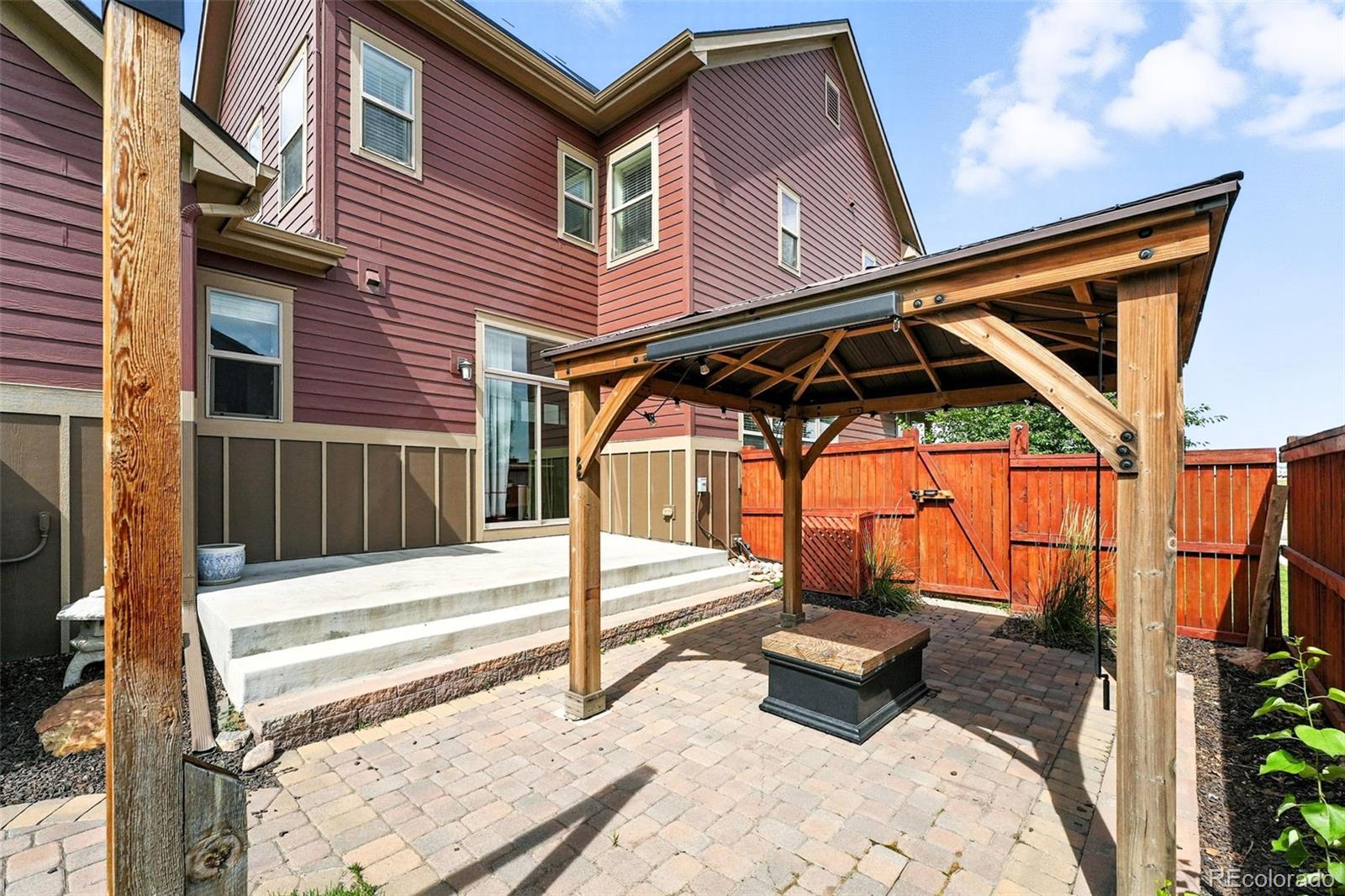 5207 Clinton Street Denver, CO 80238 - Photo 26 of 43 a white house with a small yard and wooden fence