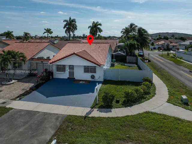 a aerial view of a house with a yard and potted plants